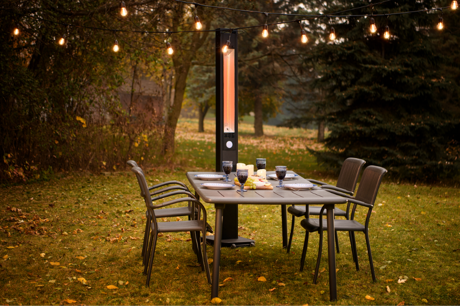 An outdoor dining setup illuminated by string lights 