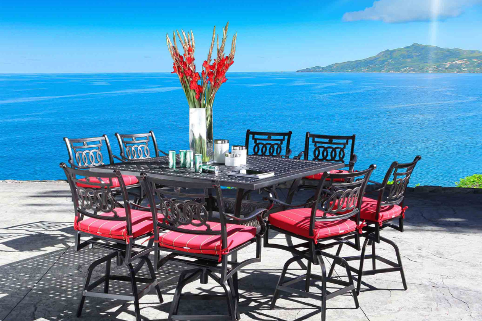 A black patio set with colourful fuchsia seats on a backyard patio with a view of the water. 